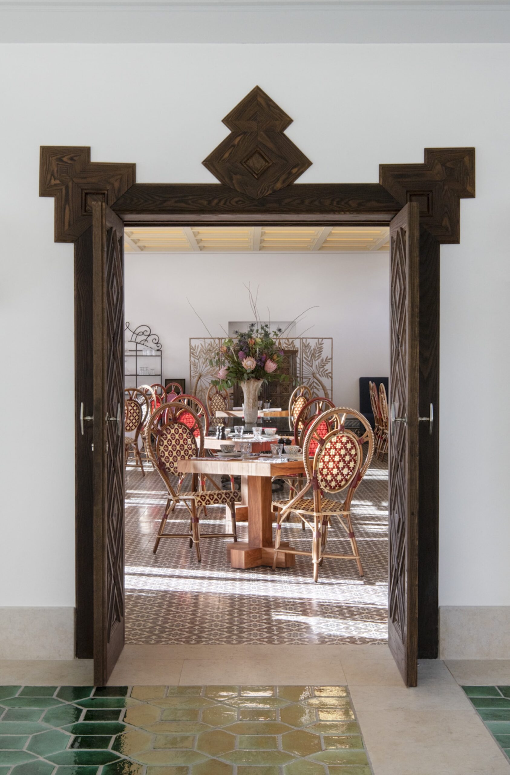 Carved wooden doorway opening into the Xtian restaurant dining room