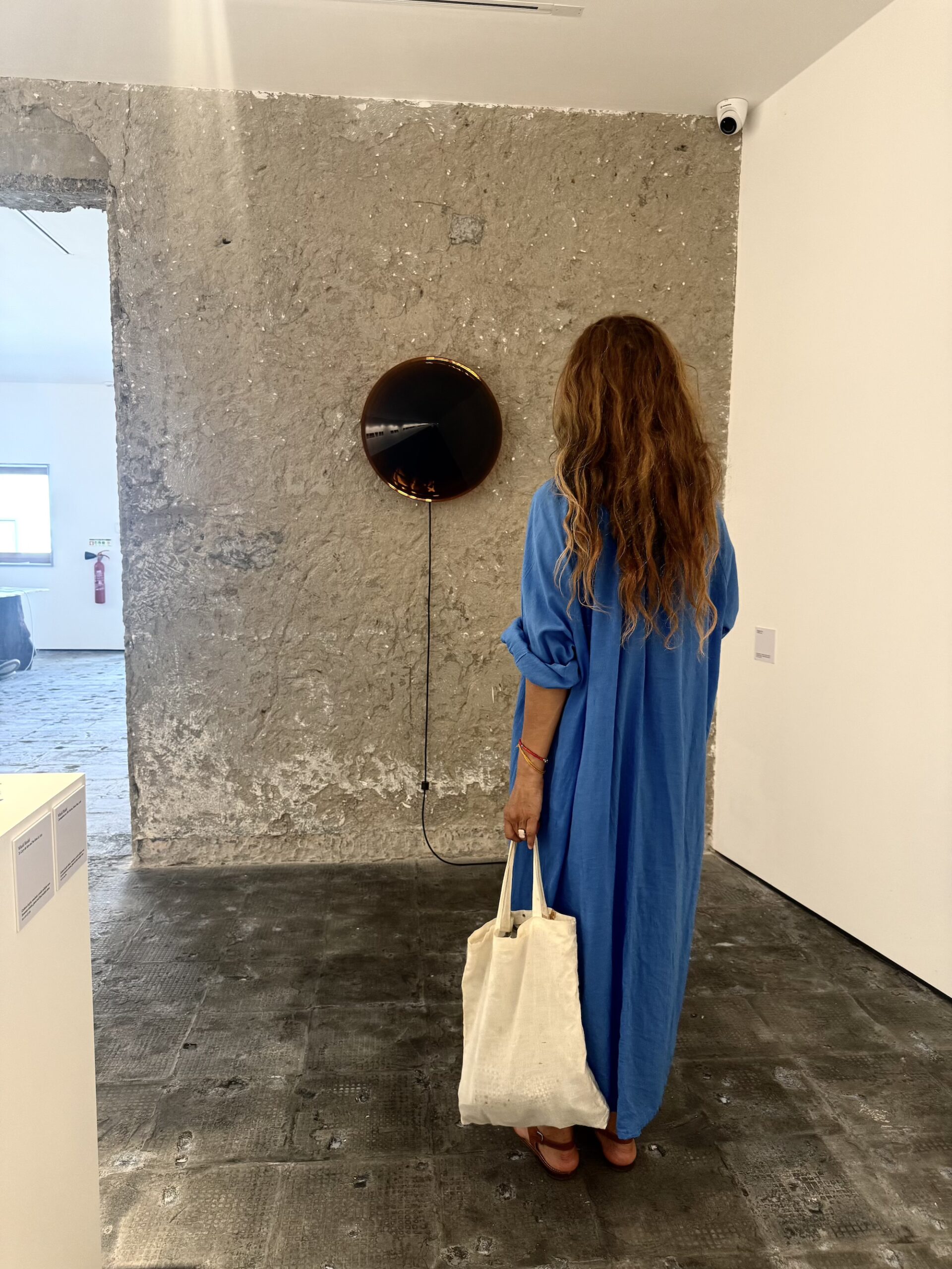 Visitor viewing an artwork at Circular gallery in Melides