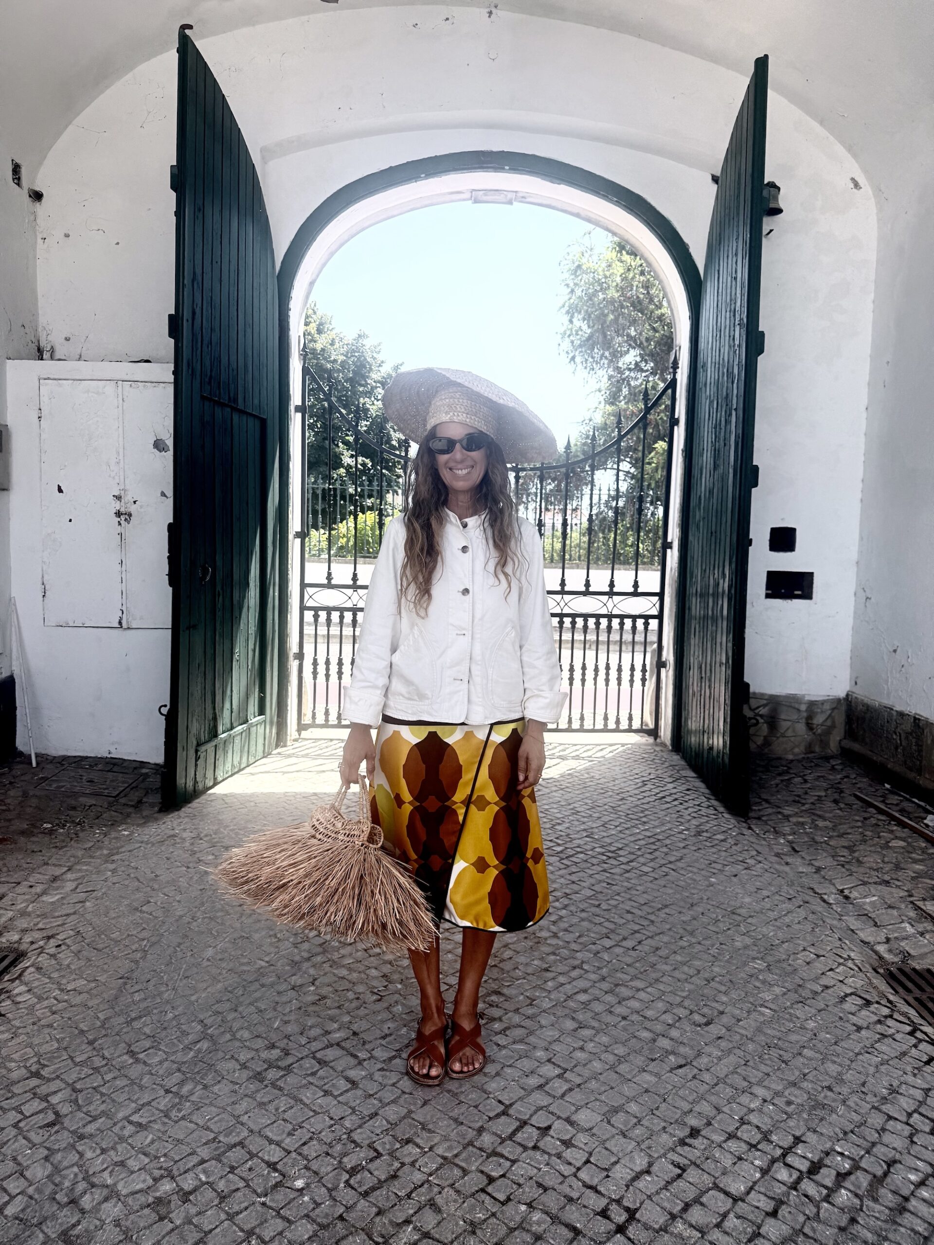 A sculptural woven palm hat and matching braided bag at the atelier gates