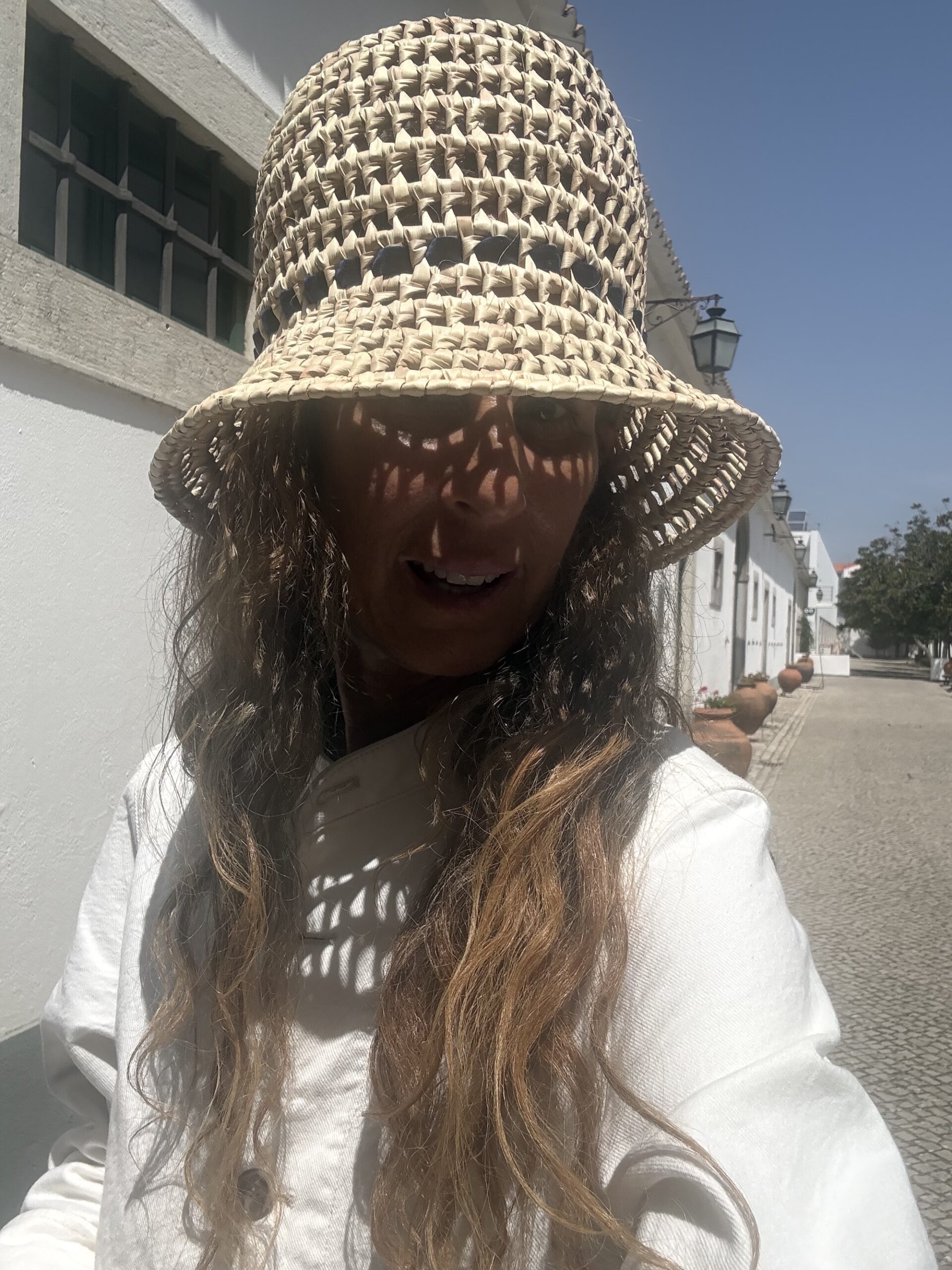A woven bucket hat worn on a cobbled street in Sao Bras de Alportel