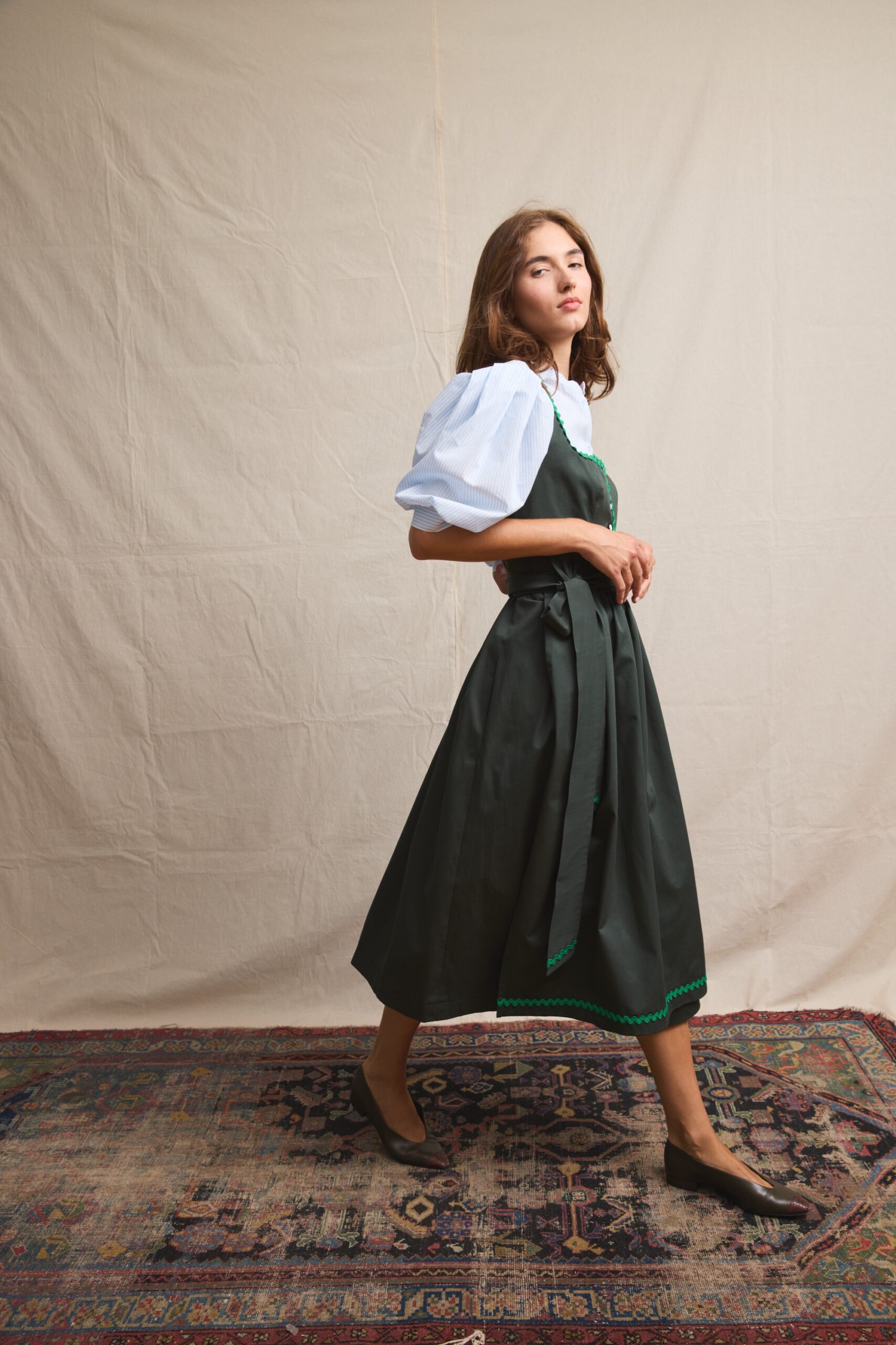 Dirndl Olivia in dark green with green rickrack trim and a light blue striped puff sleeve blouse