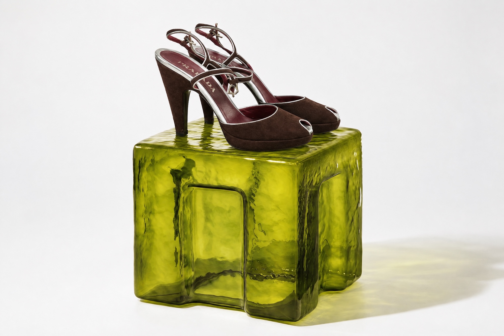 Brown suede Prada sandals on a green glass block